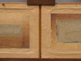 painting of two squares on a wooden easel with a blue background