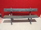 a wooden bench sitting in front of a red wall