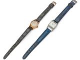 a couple of watches sitting next to each other on a white surface