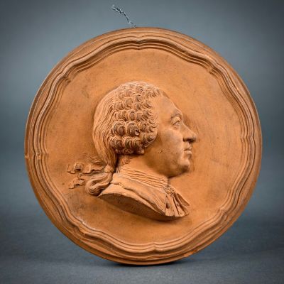 an image of a clay plaque of a man in profile