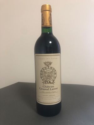 une bouteille de vin posée sur une table à côté d'un mur