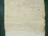 an old piece of paper with torn edges on a green surface