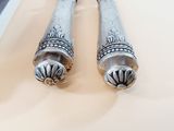 two silver spoons sitting on top of a table