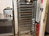 une étagère métallique sur laquelle sont posées des casseroles et des poêles, dans une cuisine