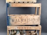 an old wooden crate with a bottle of malmaison on top