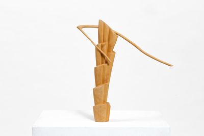 a sculpture made of wood on a white pedestal