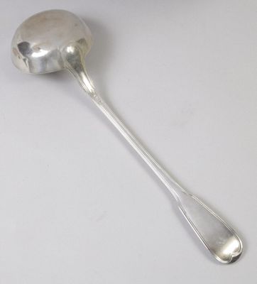 cuillère en argent avec un manche, posée sur une surface blanche