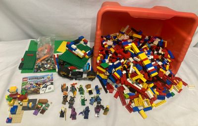 une boîte rouge remplie de Lego posée sur une table blanche