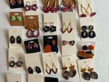 many pairs of earrings on display on the wall