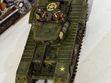 a toy army tank sitting on a table next to a book