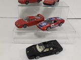 three toy cars are on display in a glass case