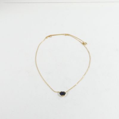 un collier en or orné d'une pierre noire sur fond blanc