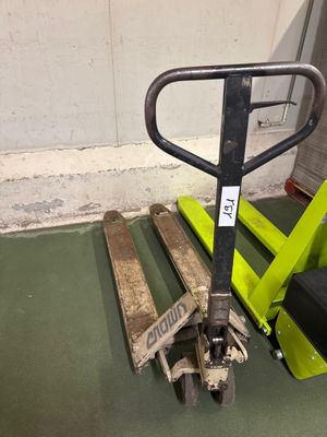 a fork lifter sitting next to a pallet in a warehouse
