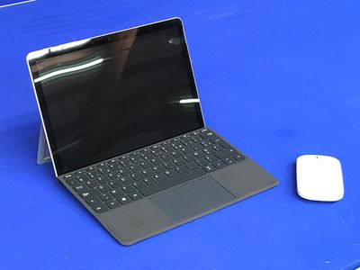 un ordinateur portable et une souris posés sur une table bleue