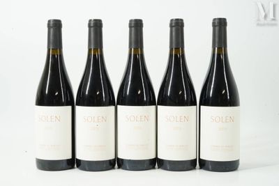 quatre bouteilles de vin sont alignées sur une surface blanche