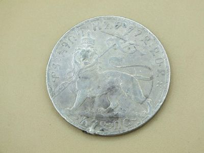 a silver coin with a picture of a lion on it