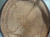 a close up of a wooden chair with a wicker seat