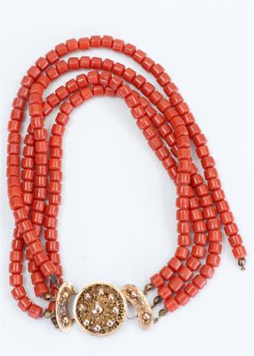 a close up of a red beaded necklace with a gold clasp