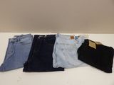 four pairs of jeans are lined up on a table