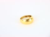 a gold ring on a white surface