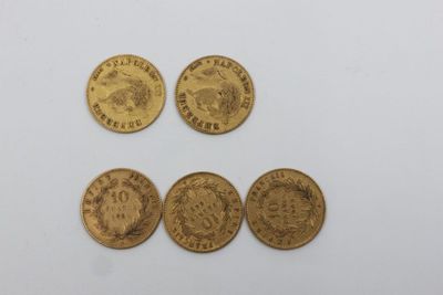 quatre types différents de pièces d'or sur une surface blanche
