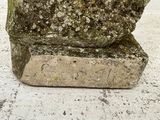 a stone vase that has moss growing on it