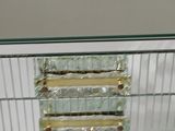 a glass and metal cabinet with a mirror on top