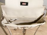 a white purse sitting on top of a wooden table
