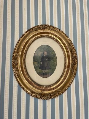 une photo d'une femme en robe noire, dans un cadre doré