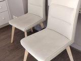 two white chairs sitting next to each other in a room