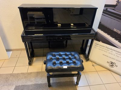 a black piano and a black stool in a room
