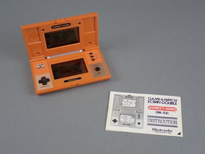 a small orange nintendo game console next to a sticker