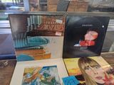 a lot of records sitting on a table in a window
