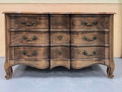 une commode en bois surmontée d'un miroir