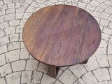 a wooden table that is on a brick floor