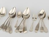 six silver spoons and a fork on a white surface