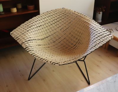 une chaise en osier posée sur un parquet dans un salon