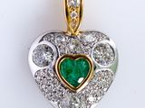an image of a diamond and emerald heart pendant on a white background