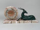 a statue of an antelope and a clock on a marble stand