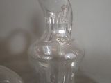 a clear glass vase sitting on a table next to a glass vase