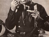 a black and white photo of a man eating a piece of cake