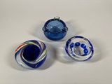three blue and white glass bowls sitting on top of a white table