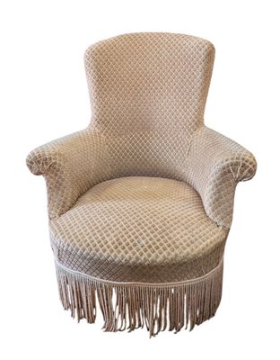 une chaise rembourrée avec des franges sur les pieds