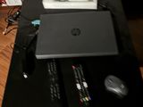 une table noire sur laquelle se trouvent un ordinateur portable, une souris et d'autres objets