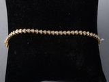 a gold bracelet on a black cushion