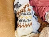 a cardboard box filled with clothes and a teddy bear