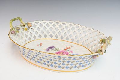 un panier blanc orné de fleurs bleues et roses