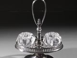 un plat ancien en argent surmonté d'un bol en verre