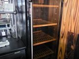 a black refrigerator with a glass door in a kitchen
