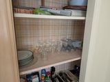 un placard de cuisine rempli de vaisselle et de verres
